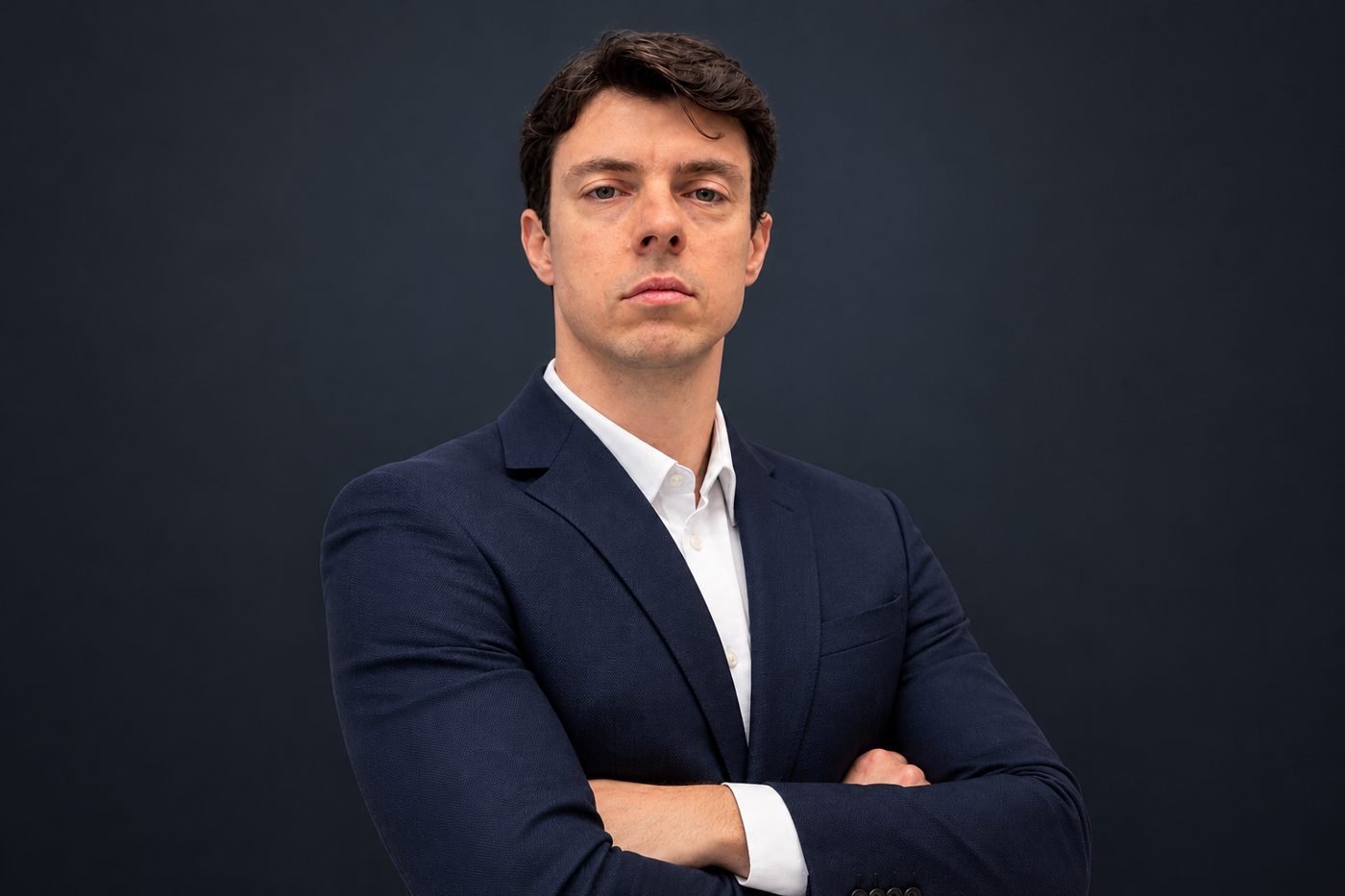 Dr. Rodrigo Gavaldão, ortopedista, de terno azul-marinho e braços cruzados